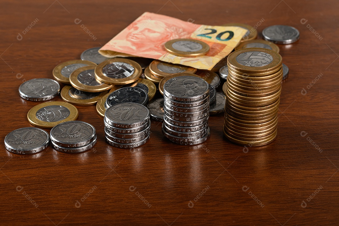 Várias moedas e notas de dinheiro sobre fundo de madeira