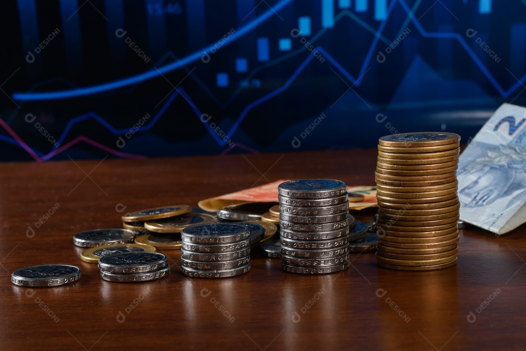 Moedas e dinheiro sobre uma mesa de madeira com fundo de gráfico