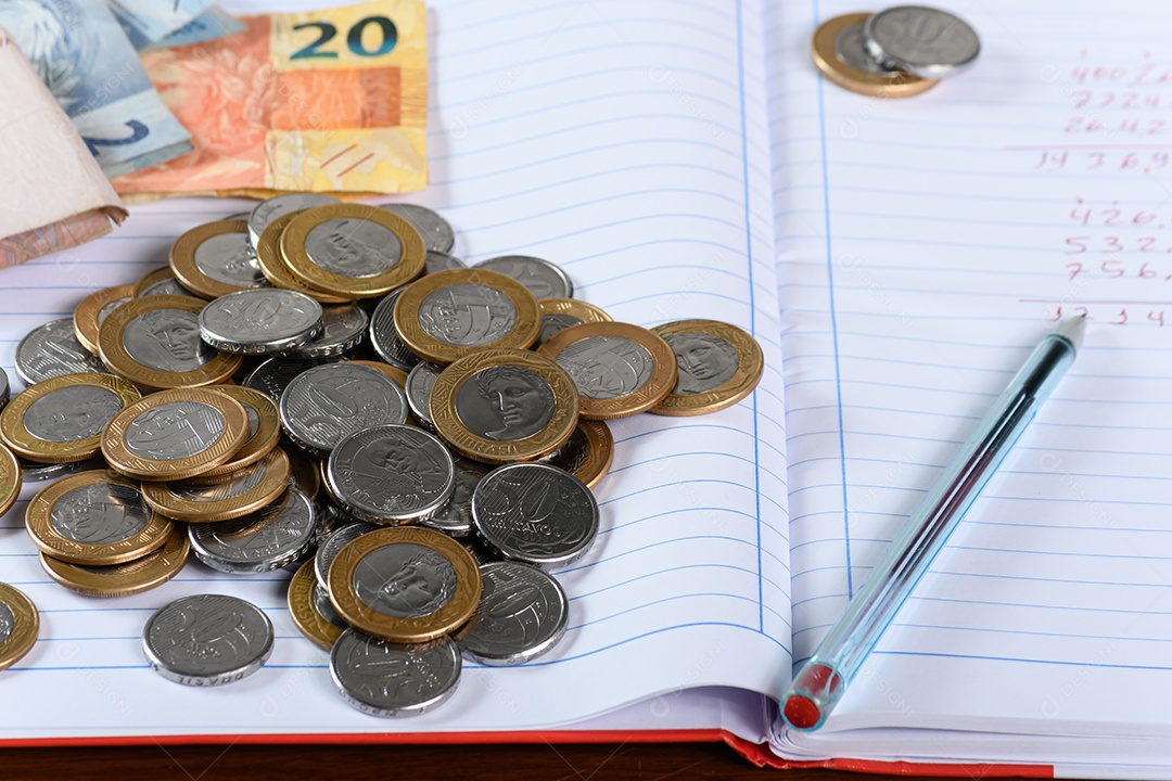 Caderno com dinheiro e moedas
