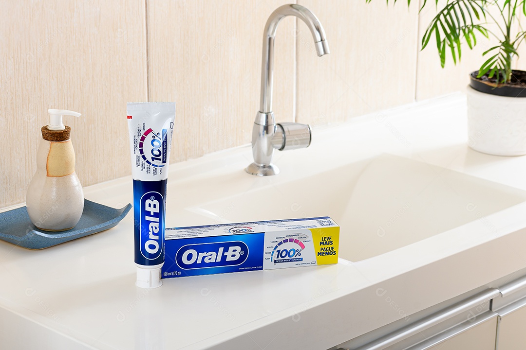 Creme dental oral b sobre uma pia de banheiro