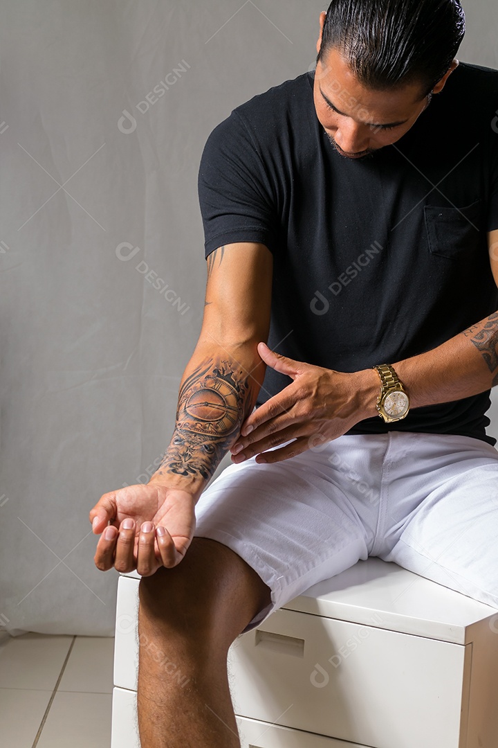 Um homem charmoso moderno mostrando tatuagem