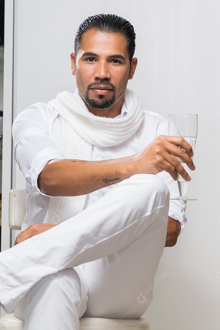 Um lindo homem sentando e tomando alguma coisa