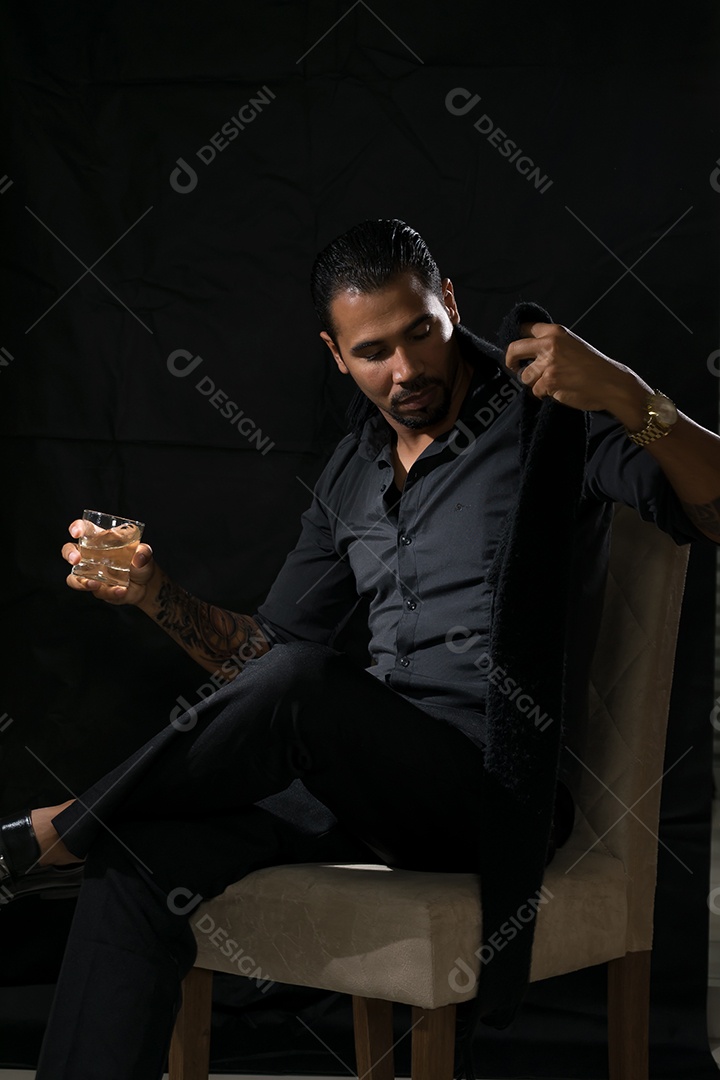 Um homem charmoso moderno sentando tomando um whisky