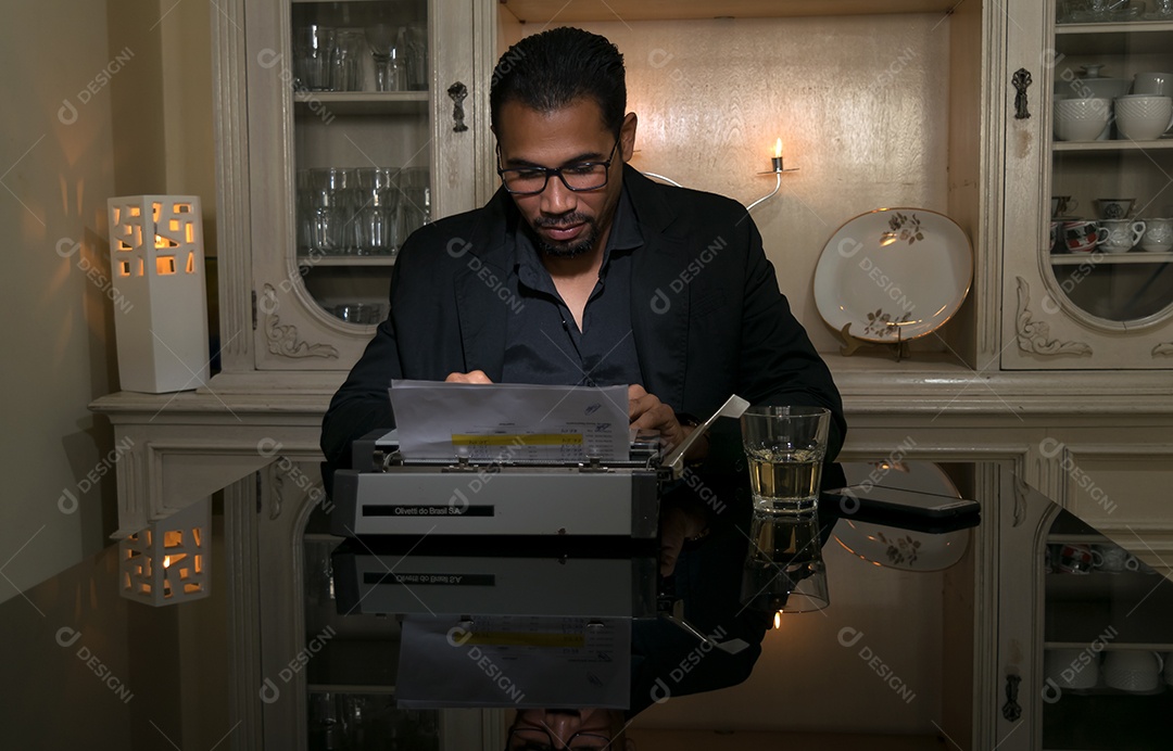 Um homem moderno lindo bebendo whisky e ditalografando a moda antiga