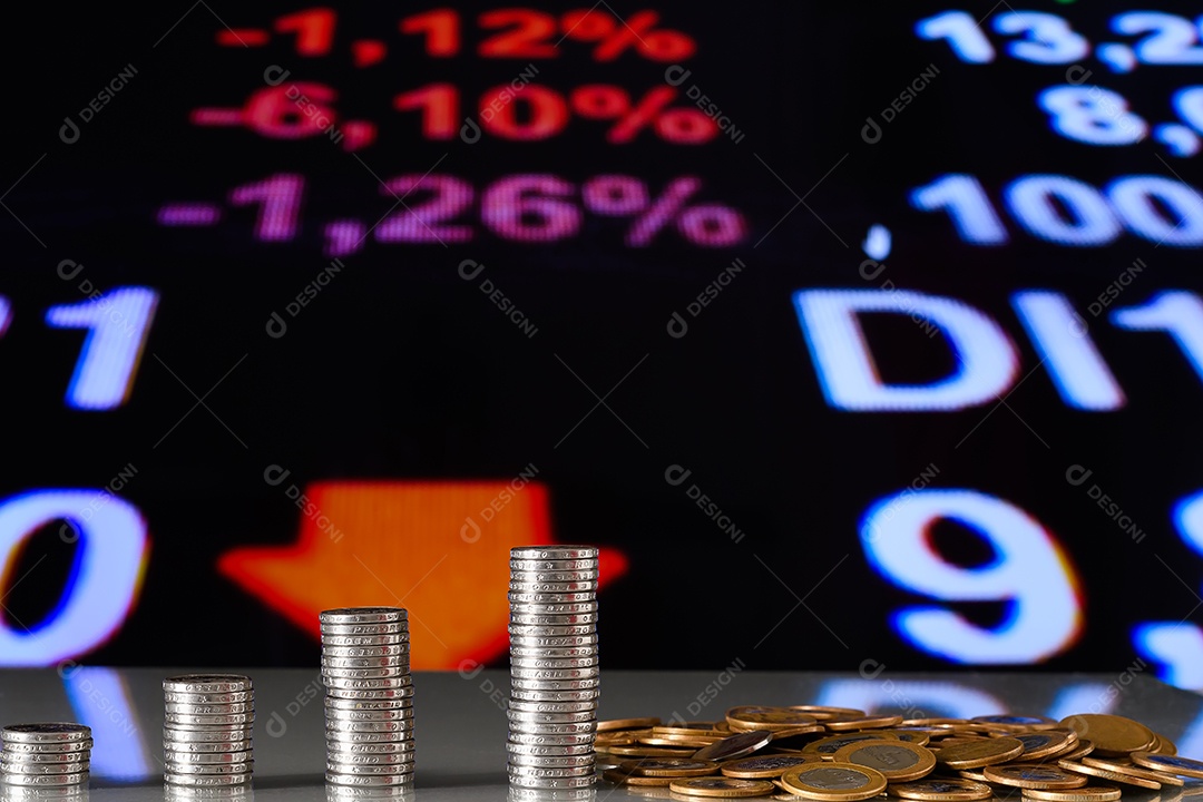 Várias moedas empilhadas sobre uma mesa de madeira