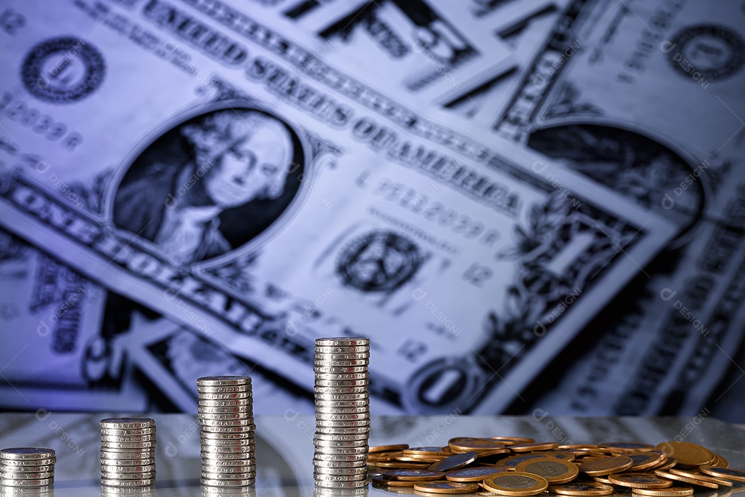 Várias moedas de cinquenta centavos empilhadas sobre fundo de dólares