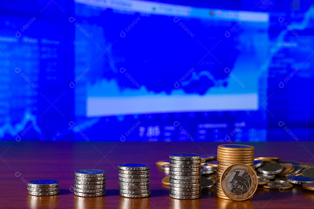 Várias moedas empilhadas sobre uma mesa de madeira