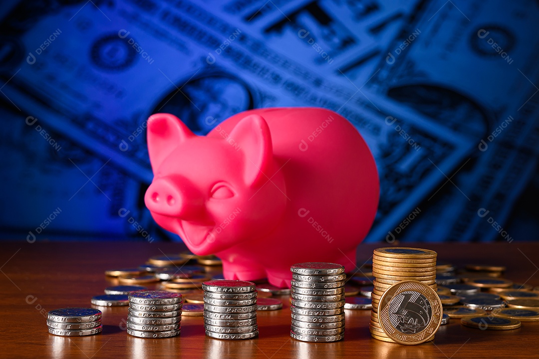 Moedas empilhadas sobre uma mesa e porquinho simbolizando poupança