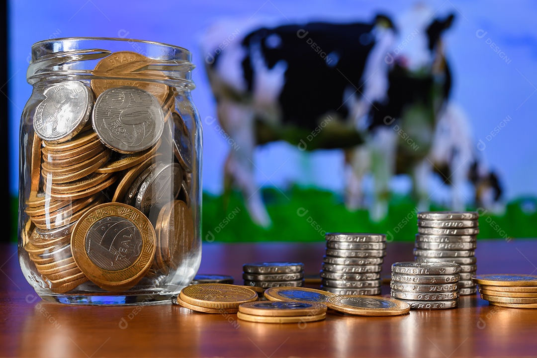 Um pote de vidro cheio de moedas sobre uma mesa de madeira