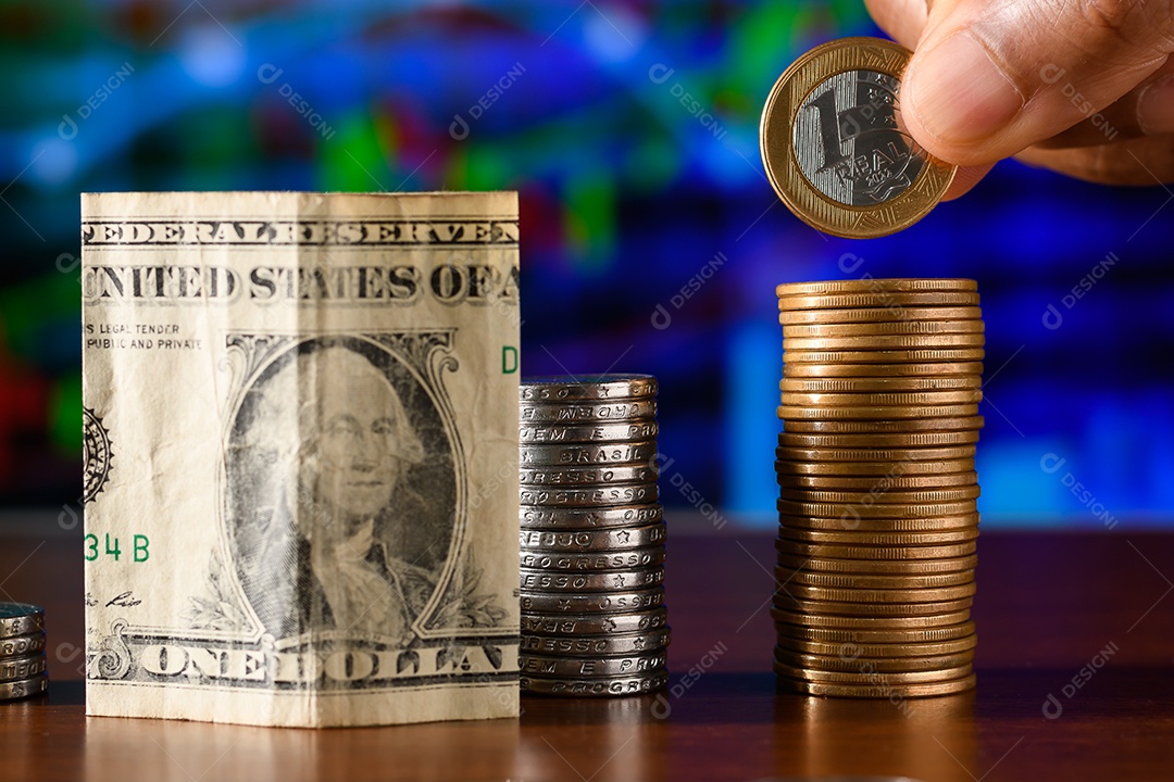 Cédula de dinheiro e moedas empilhadas sobre uma mesa