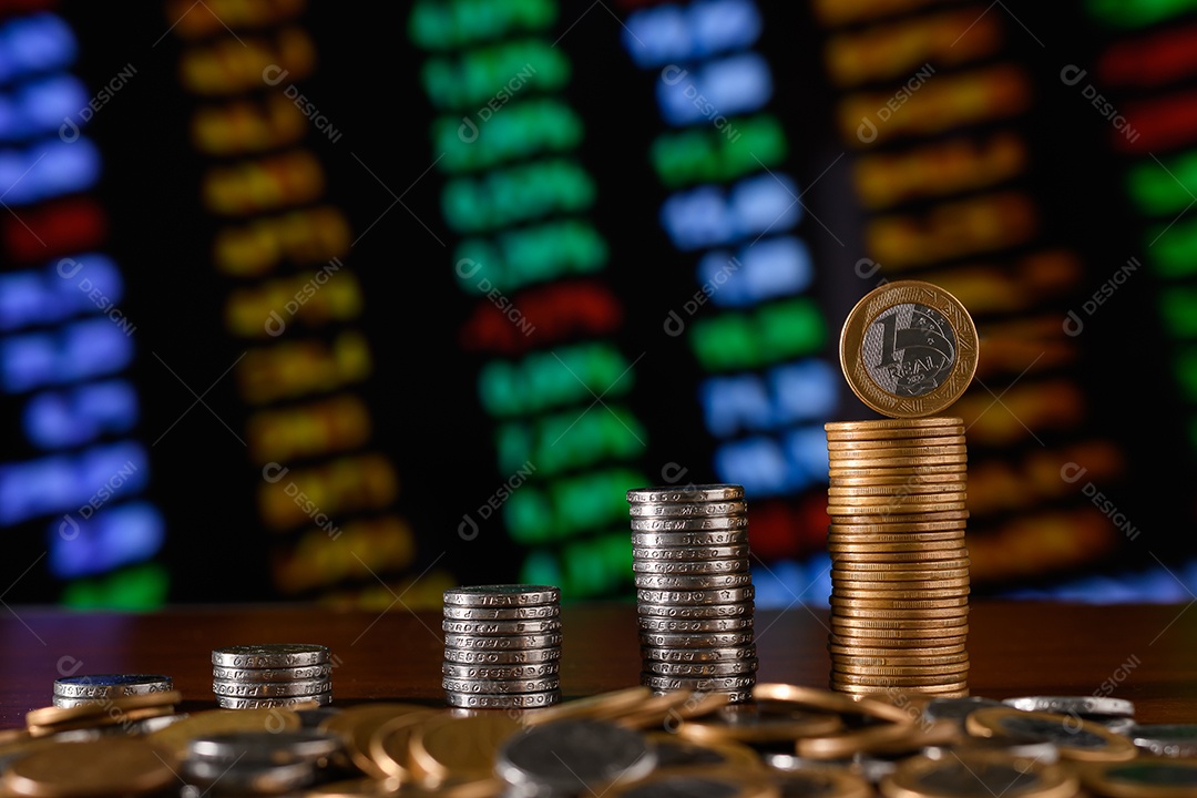 Várias moedas empilhadas sobre uma mesa de madeira