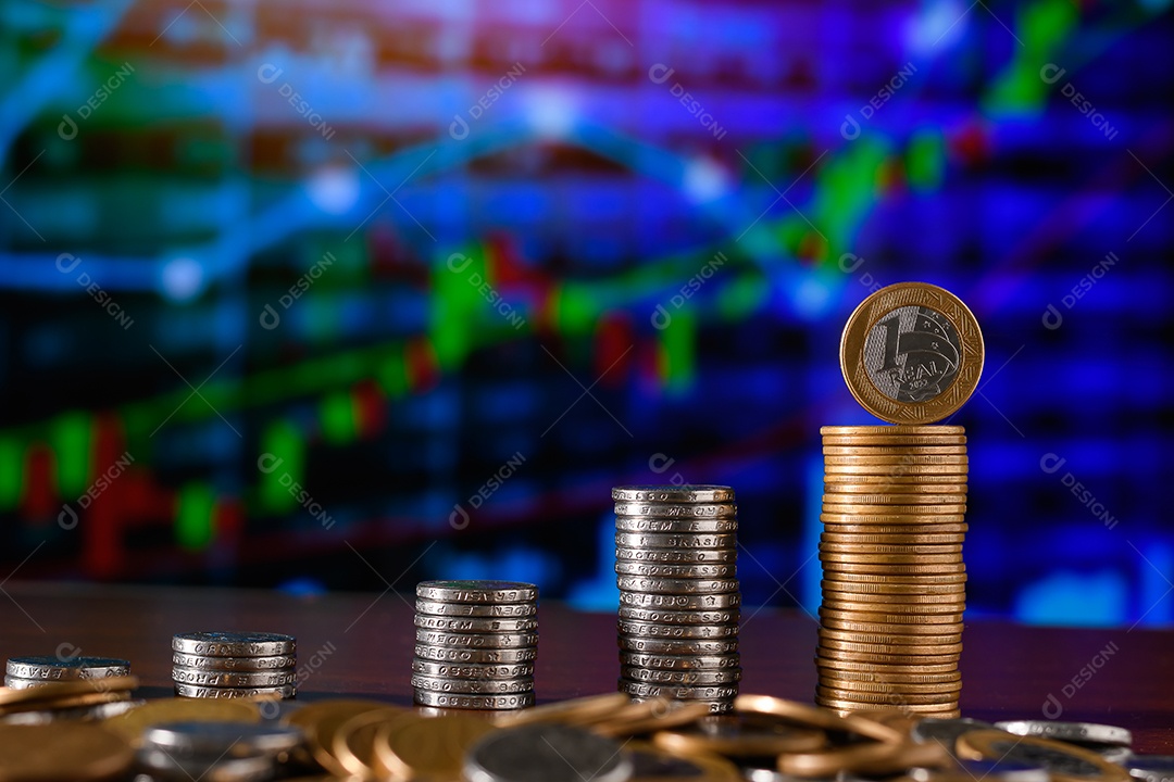 Várias moedas empilhadas sobre uma mesa de madeira