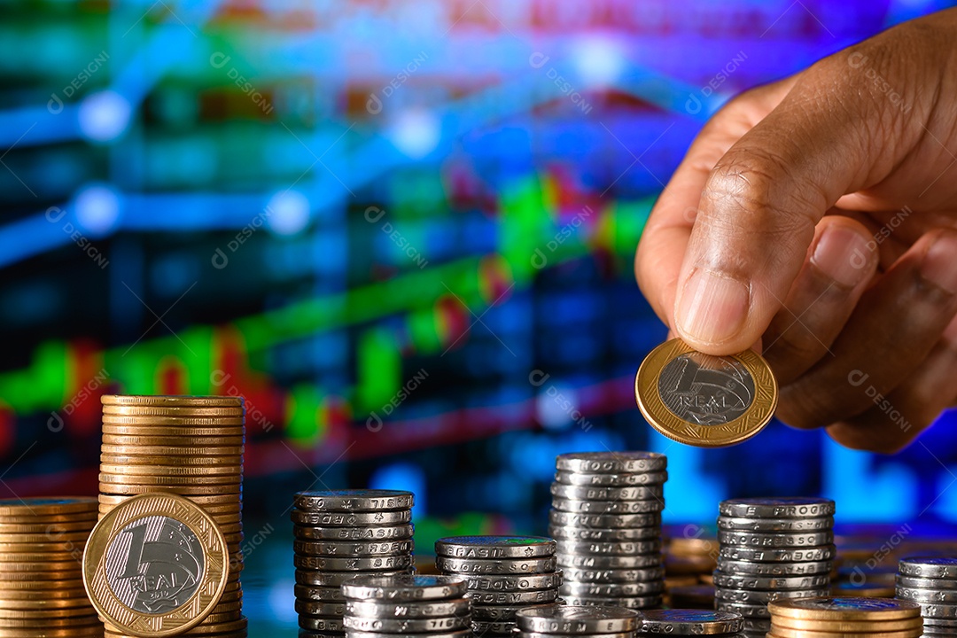 Mãos empilhando moedas sobre fundo de gráfico