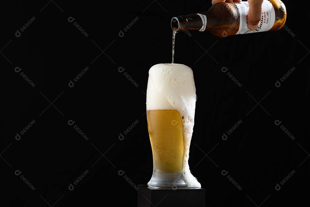 Copo com cerveja sobre fundo preto