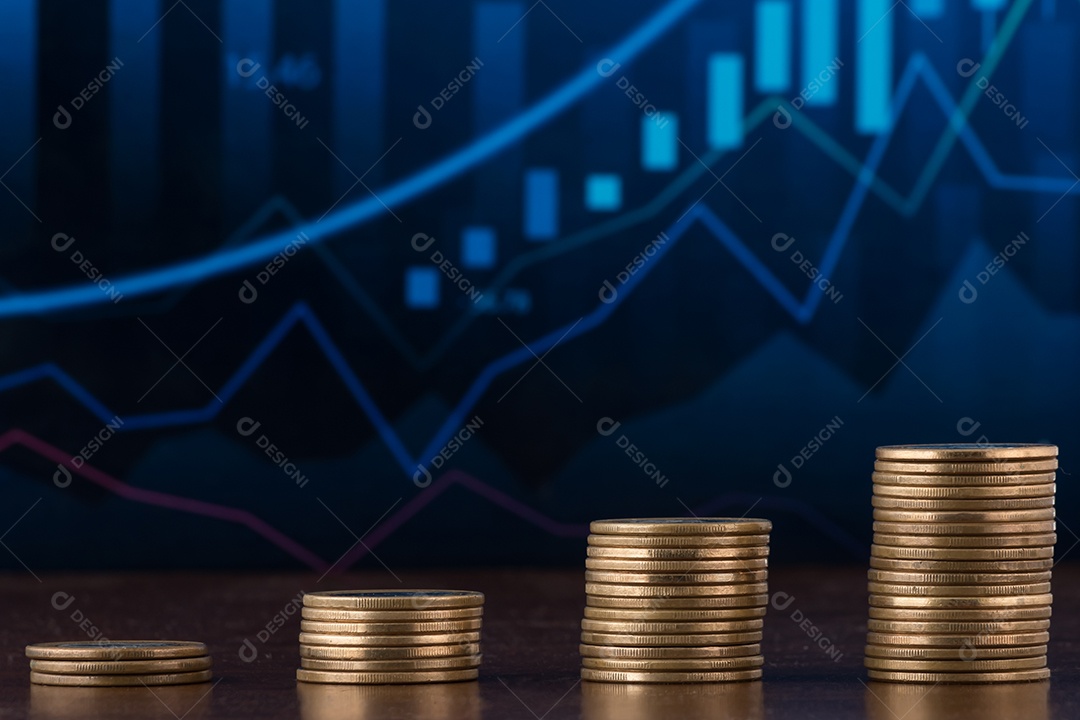 Moedas de um real empilhadas sobre uma mesa madeira