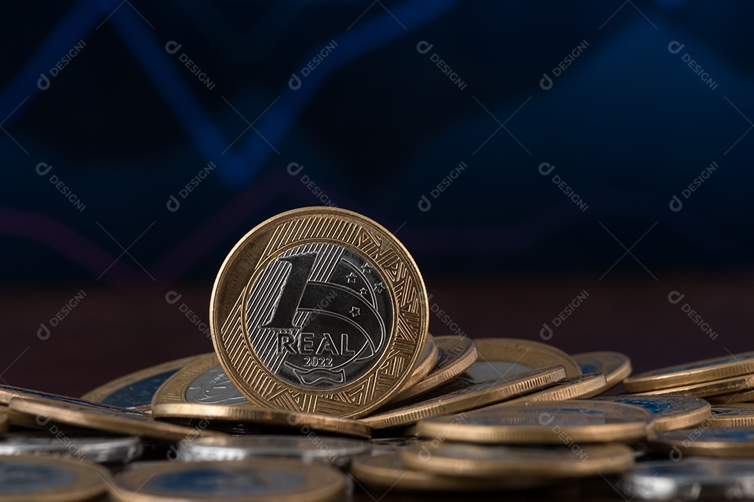 Muitas moedas de um real sobre mesa de madeira