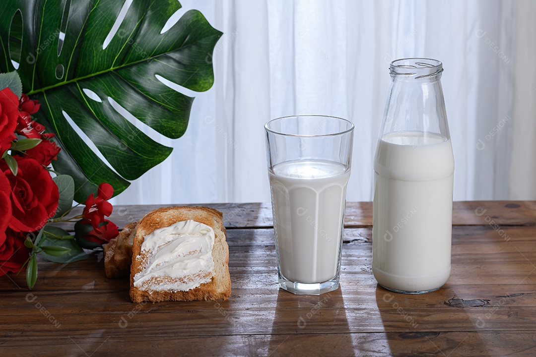 Copo e garrafa com leite e torradas com requeijão