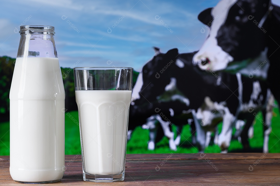 Garrafa de vidro com leite e copo sobreum fundo de bovino