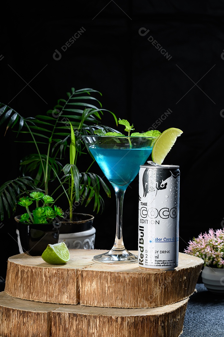 Tábua de madeira com taça de drink e red bull