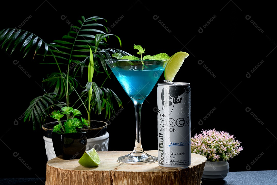 Tábua de madeira com taça de drink e red bull