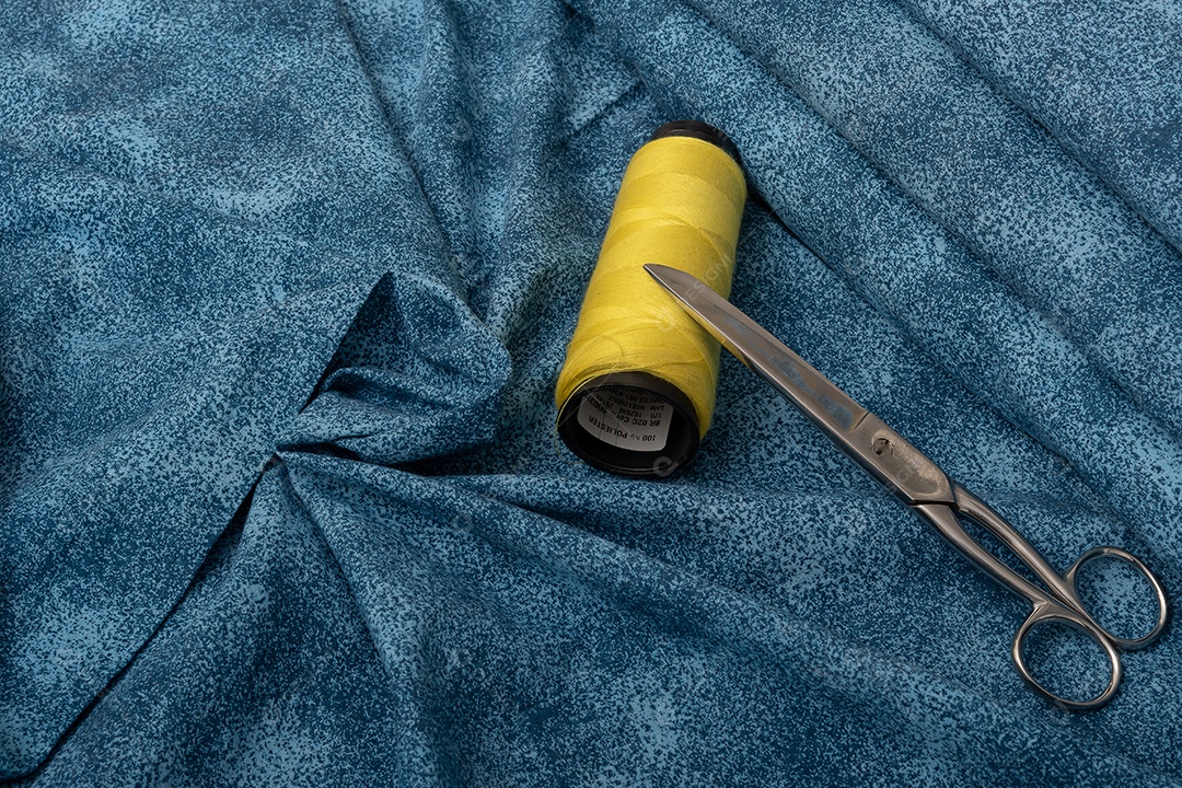 Tecido com linha colorida e tesoura