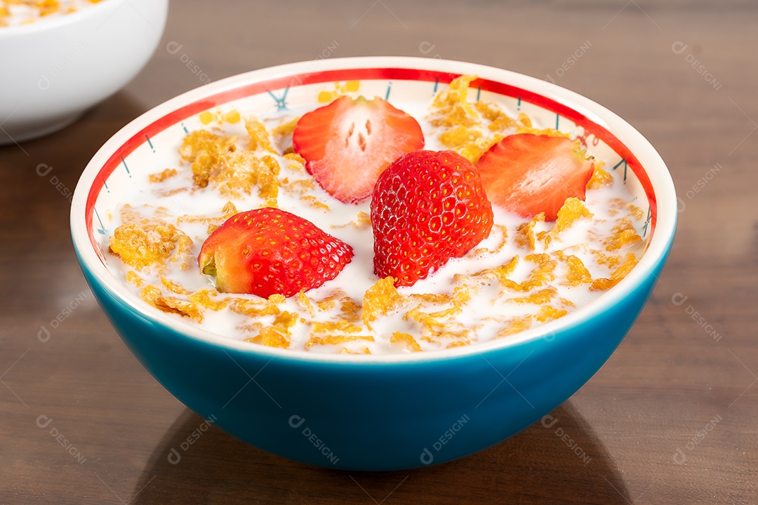 Tigela azul ccom leite cereal e morangos