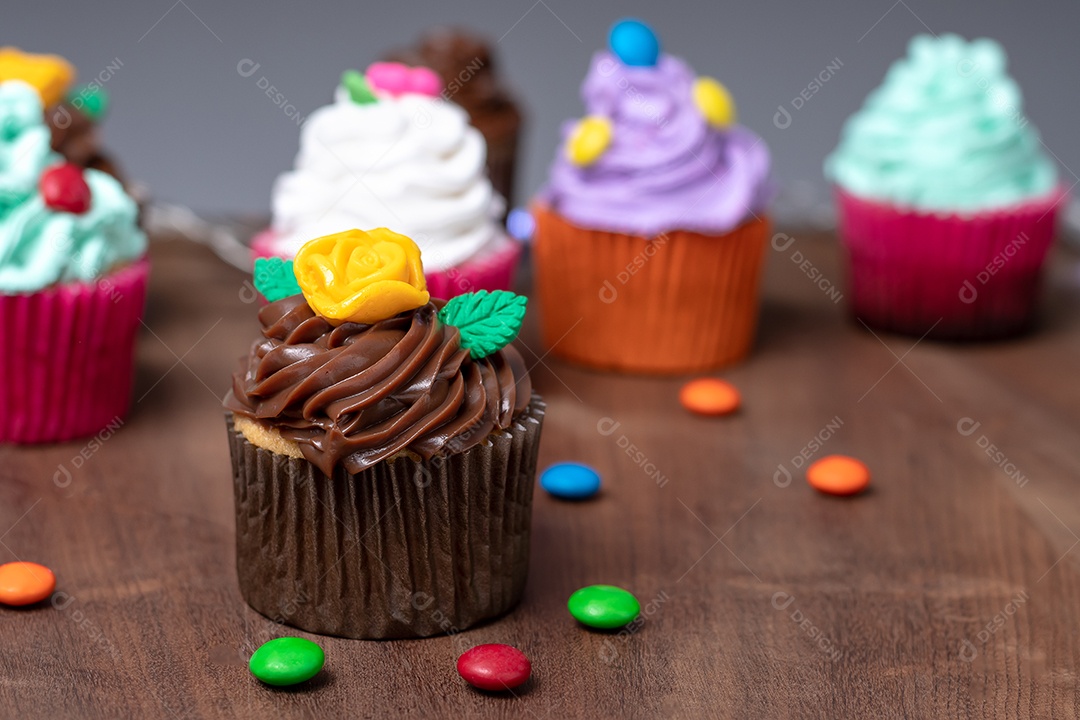Cupcakes com decoração sobre mesa de madeira