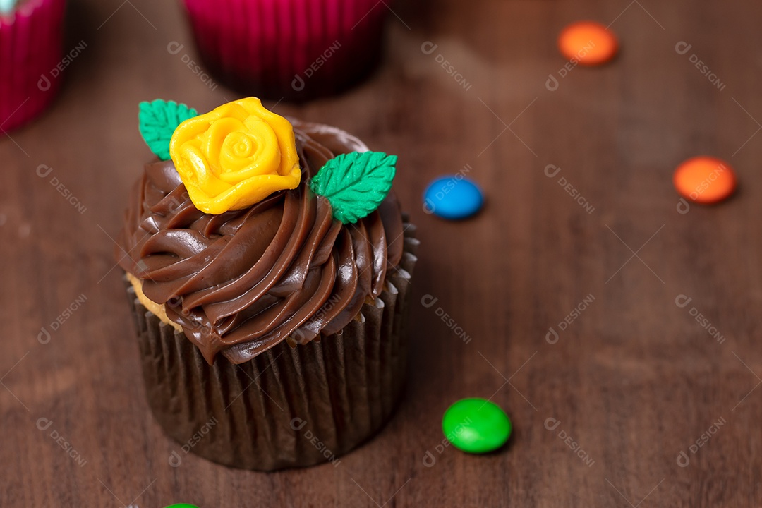 Cupcakes com decoração sobre mesa de madeira