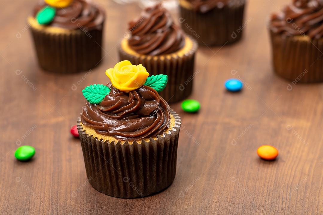 Cupcakes com decoração sobre mesa de madeira