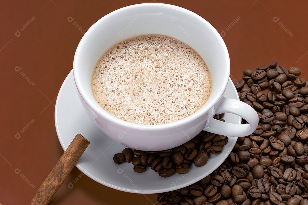 Xícara com cappuccino canela e grãos de café