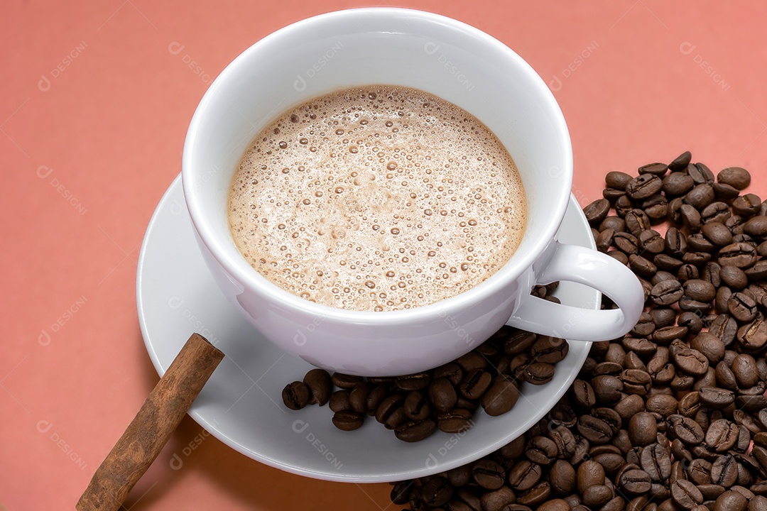 Xícara com cappuccino com canela e grãos ao lado