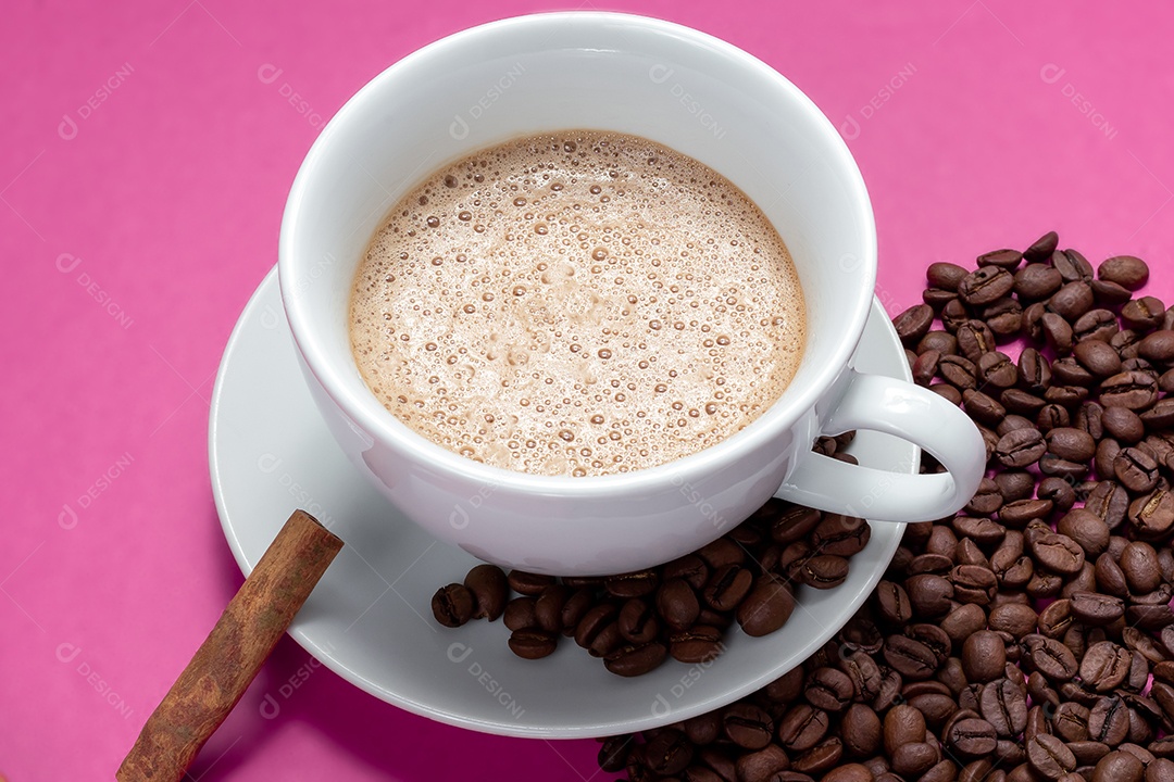 Xícara com cappuccino com canela e grãos ao lado