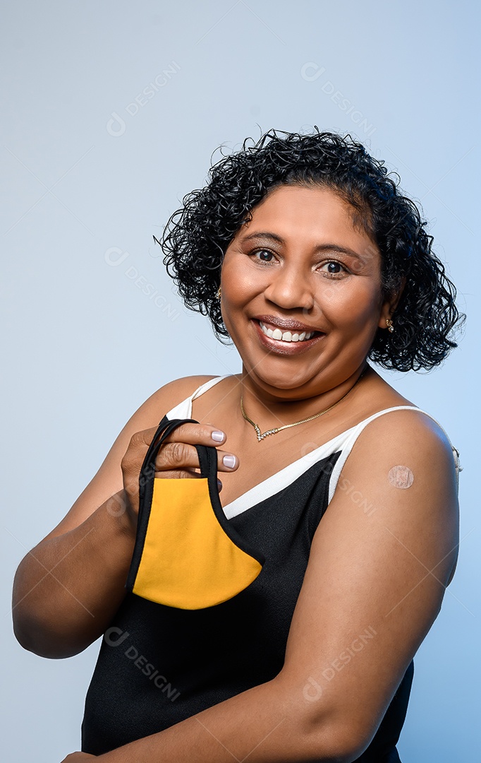 Mulher feliz com máscara nas mãos e sinal de vacinação