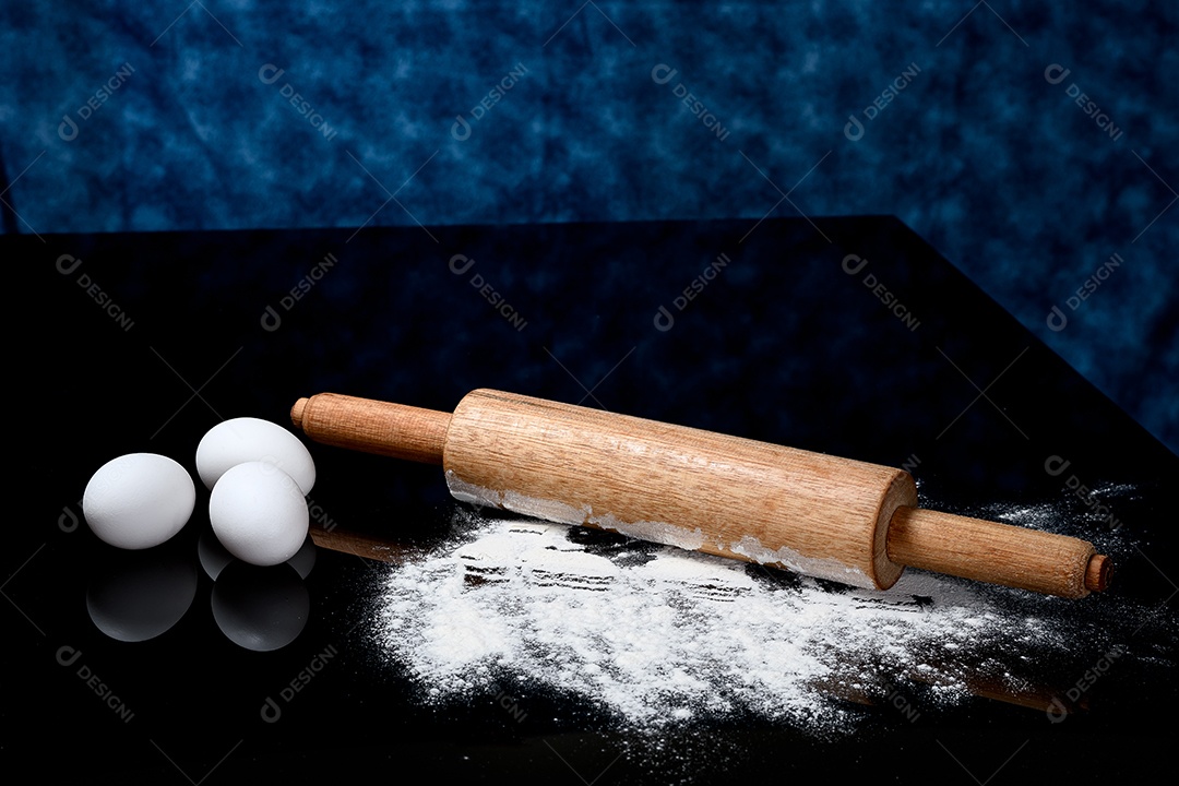 Ovos e um rolo sobre bancada de uma cozinha