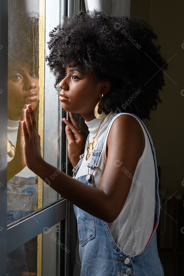 Uma linda jovem morena olhanddo atráves da janela de vidro