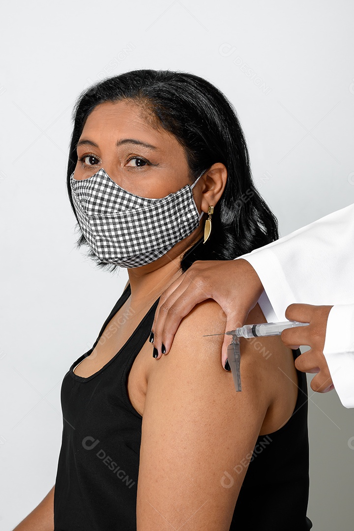 Mulher de máscara tomando injeção