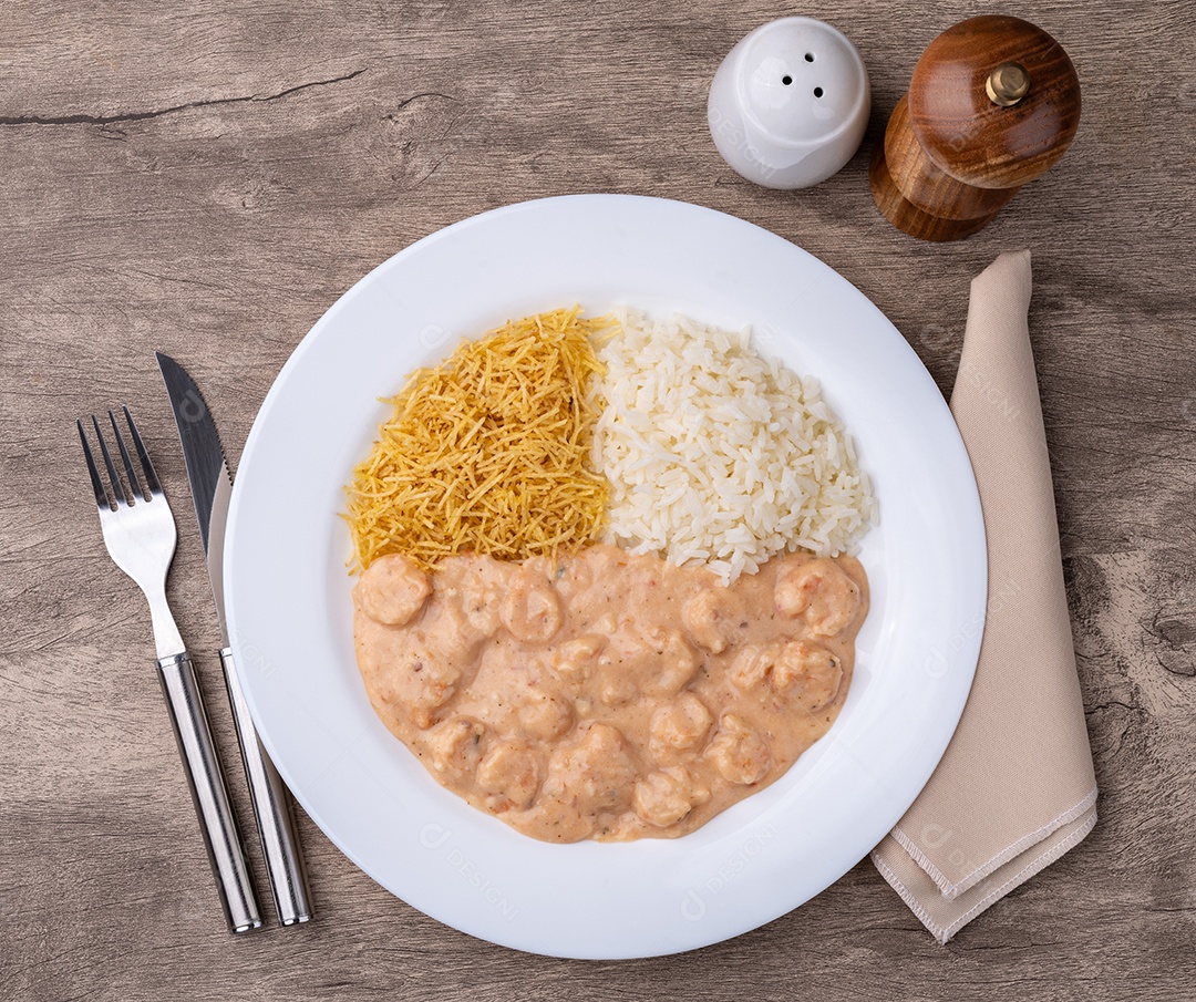 Prato com comida deliciosa estrogonofe de camarão com arroz e batata palha