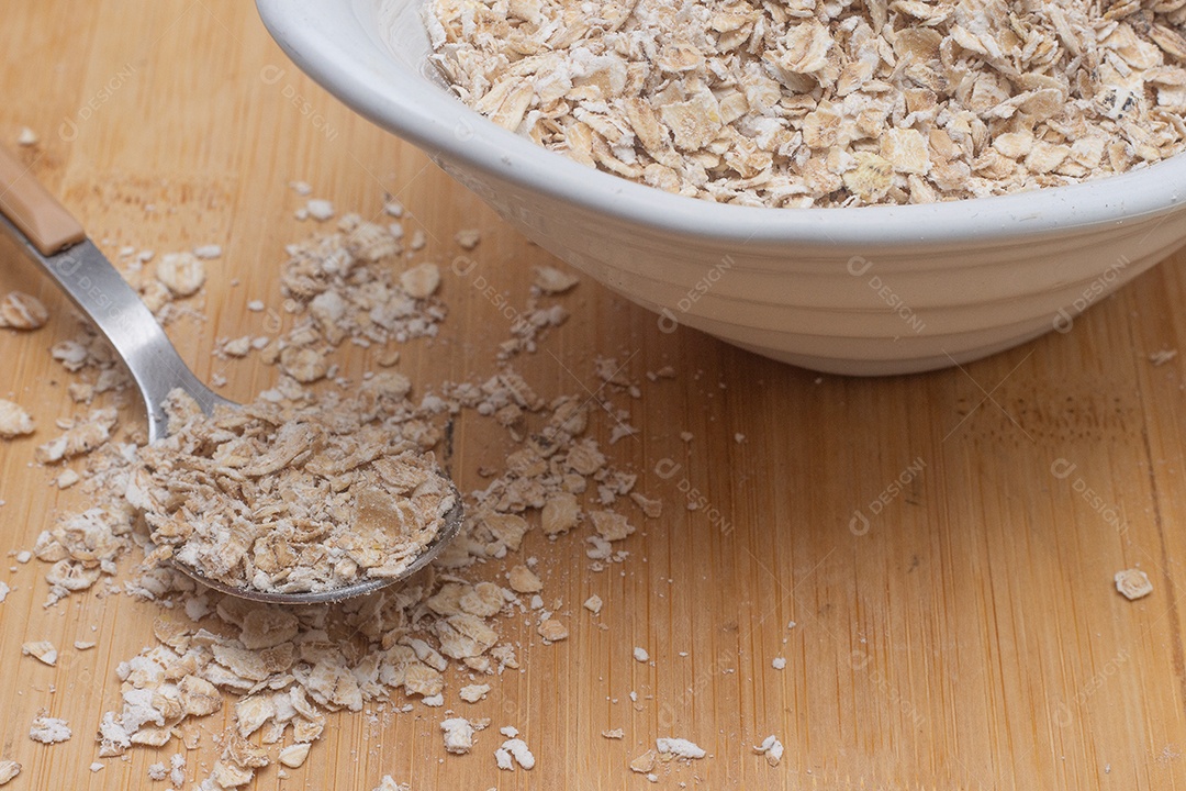 Colher pegando aveia de dentro da tigela