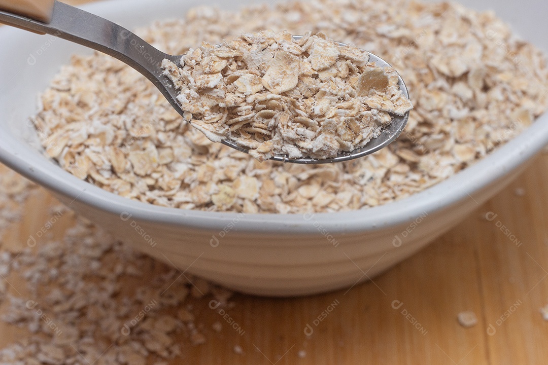 Colher pegando aveia de dentro da tigela