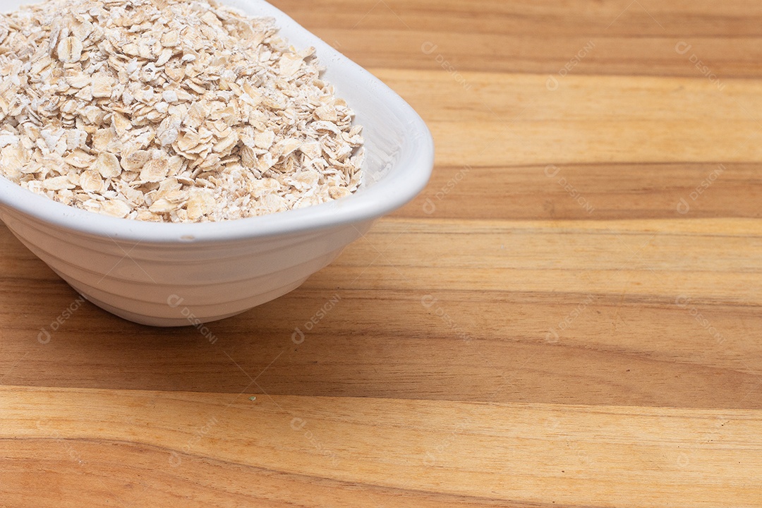 Tigela cheia de aveia com uma colher ao lado