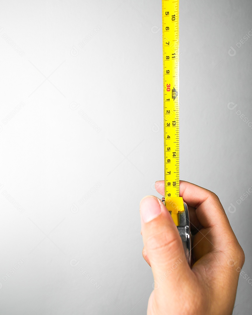 Mão segurando uma fita métrica