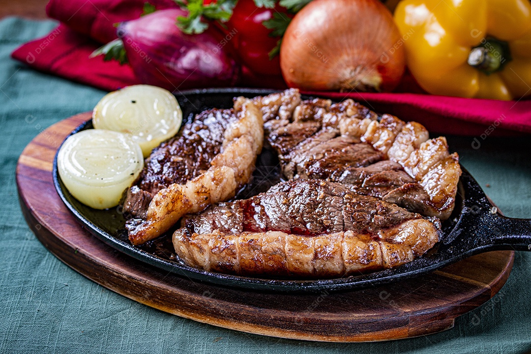Picanha fatiada grelhada com cebola sobre frigideira
