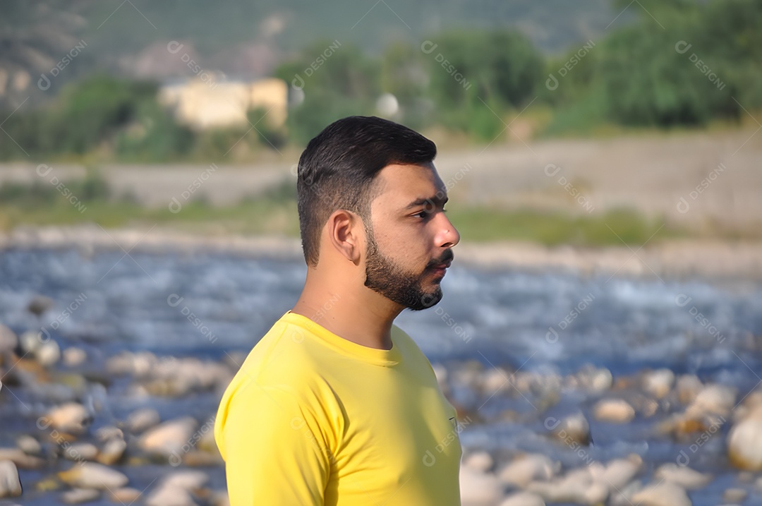 Jovem bonito com uma barba estilosa em uma camiseta amarela