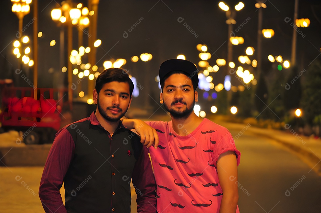 Retrato de dois jovens amigos juntos na rua à noite
