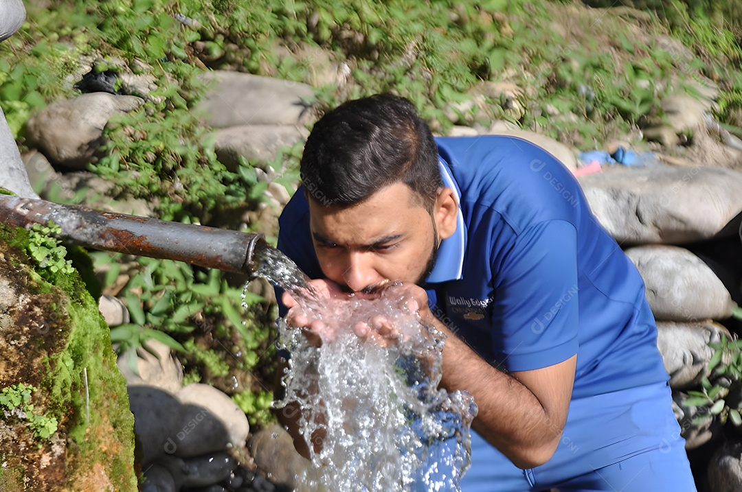 Homem bebendo água de uma fonte de jardim