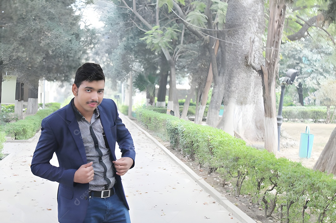 Homem indiano com roupa social fazendo pose em um parque