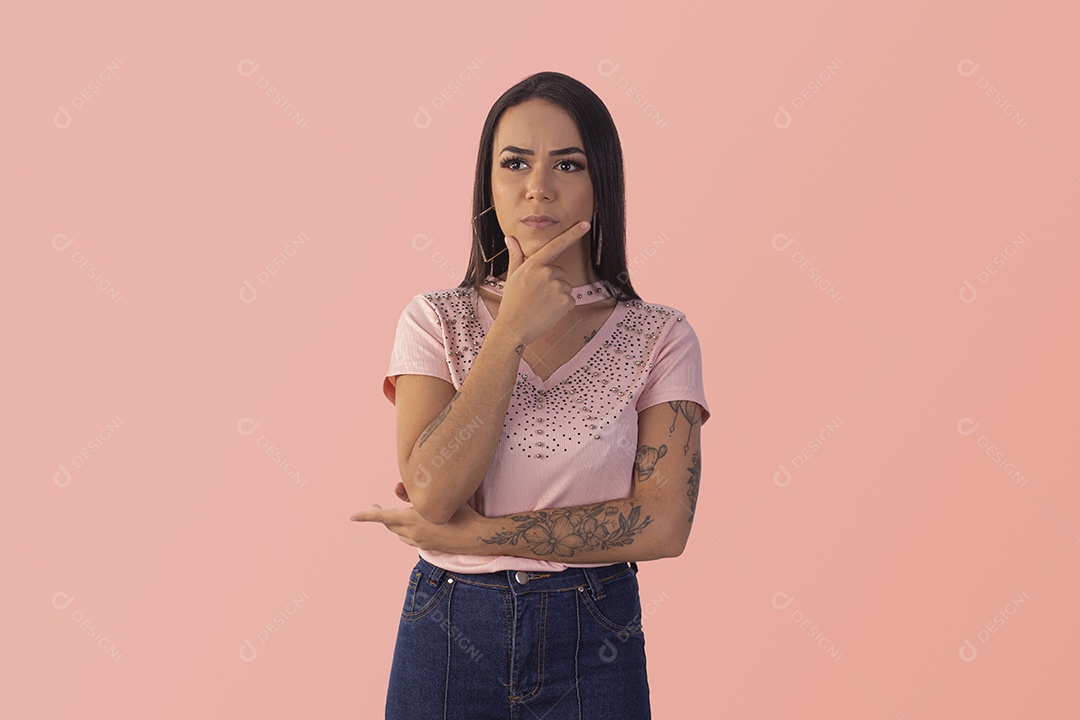 Jovem com feição de brava e mãos no queixo