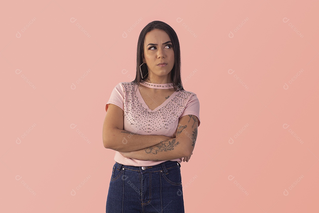 Mulher pensativa olhando para o lado com braços cruzados