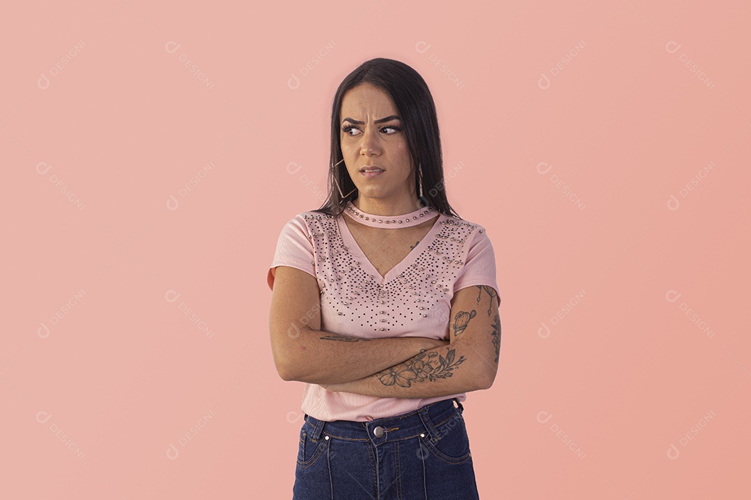 Jovem com feição de brava e braços cruzados