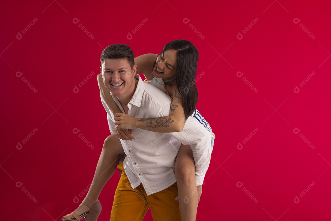 Homem com sua mulher nas costas felizes tirando fotos para casamento